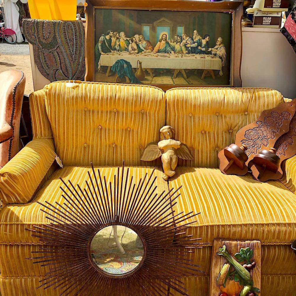 mustard couch with various home decor items