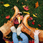 Mom and baby sitting on lawn with Fall leaves