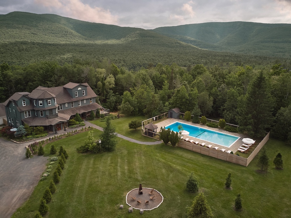 Hotel Lilien Pool and house with mountains in the back drop in Tannersville NY