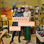 two women standing in their space at Red Flea + Collective with the "Upstate Weekend Plans" text written across the Hudson Valley, NY photo.