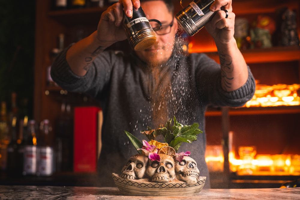 Anton Kinloch garnishing food with cinnamon at Lone Wolf Cocktail Bar in Kingston, NY.