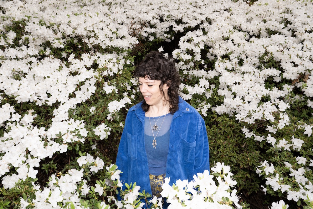DJ Sarah van Buren in a bush of flowers