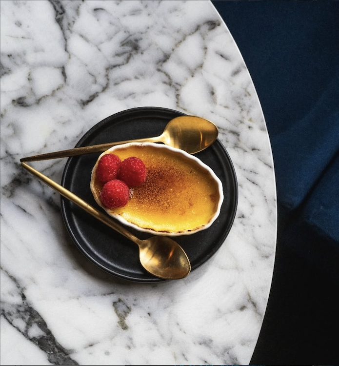 Plated Creme Brulee on marble table at Lone Wolf Cocktail Bar in Kingston, NY.