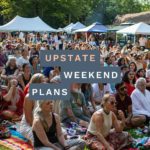 Photo of the audience listening to kirtan music at the Woodstock Festival of Awakening in 2024 with the "Upstate Weekend Plans" text written across the Hudson Valley, NY.