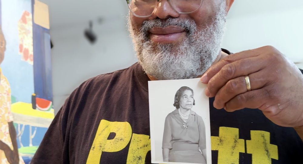 in the studio with Hudson Valley Artist Ransome holding up photo of grandmother