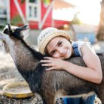 a young child hugging a goat