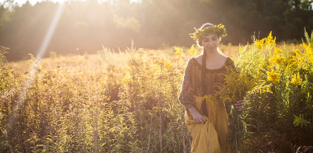 Sasha Botanica walking through a field of Goldenrod in the Hudson Valley NY