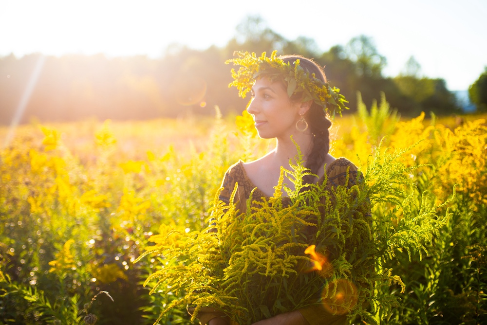 Sasha Botanica walking through a field of Goldenrod in the Hudson Valley NY
