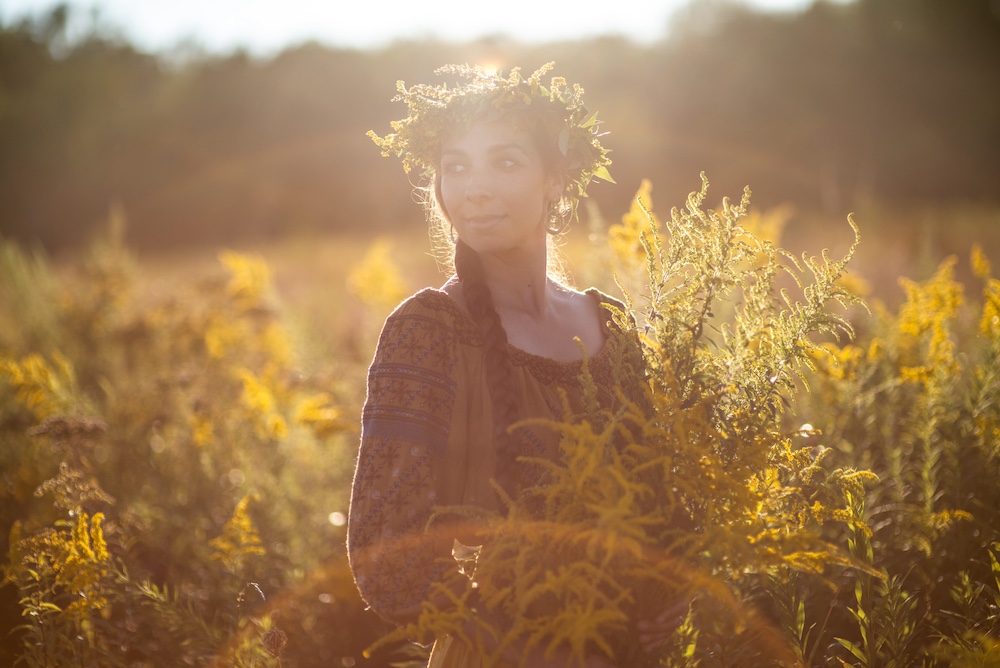 Sasha Botanica walking through a field of Goldenrod in the Hudson Valley NY