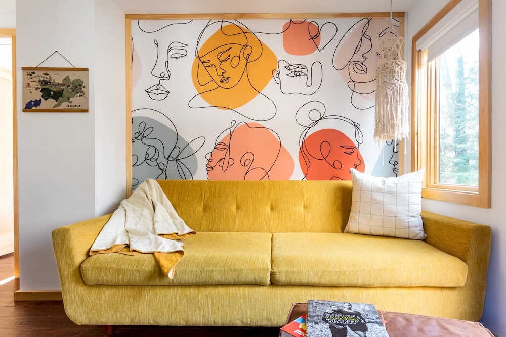 yellow funky couch and art in the suite at The Herwood Inn in Woodstock NY