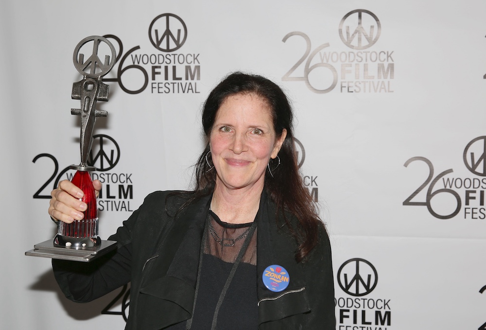 Director Laura Poitras of Cover Up holding up a trophy as a winner