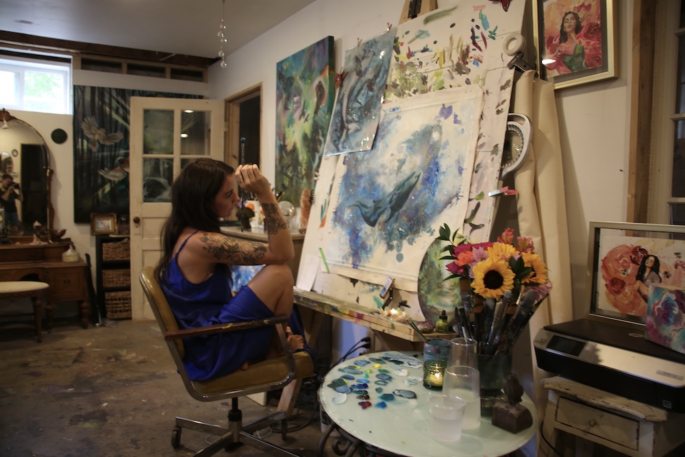 contemplating the her painting in her art studio by Artist Tara Bach in Saugerties NY