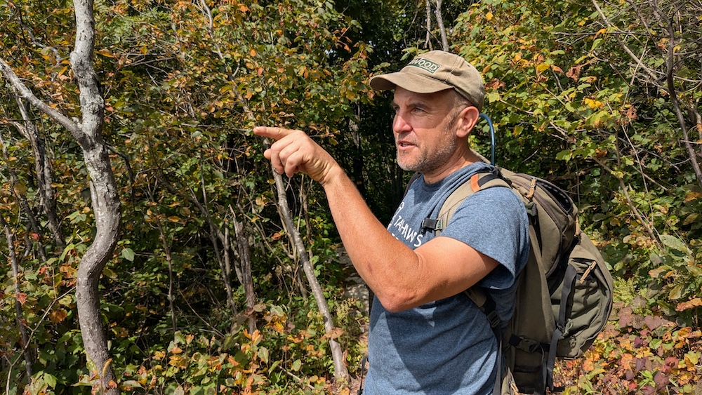 Eddie Walsh pointing at the view of the mountain on a hike in the Catskills