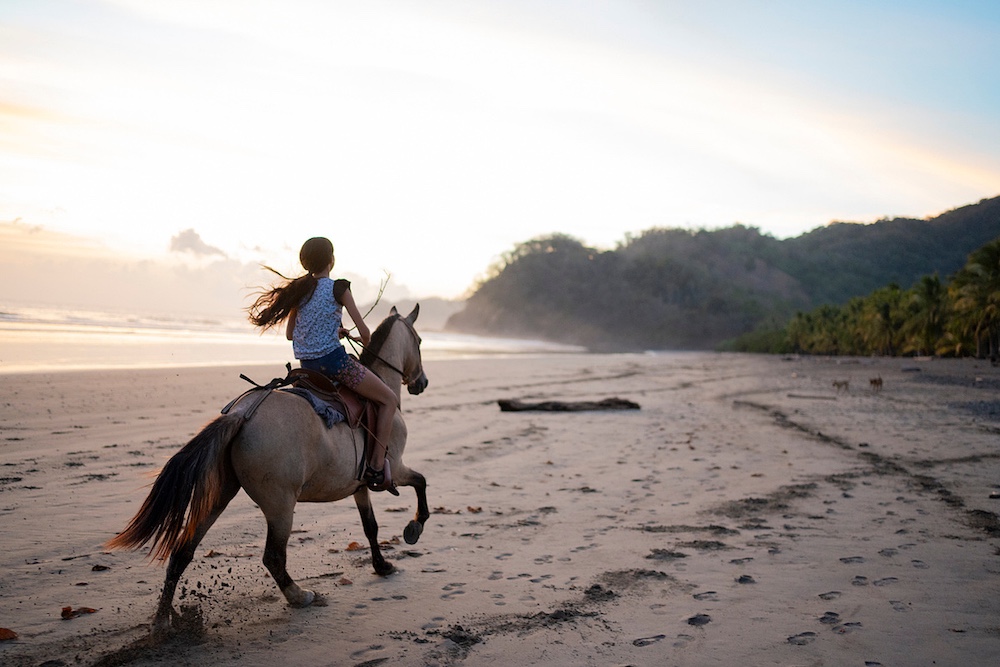 girl riding on a horse on the beach by Photographer Brooklyn Zeh