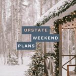 snowy cabin in the woods with holiday decorations with the "Upstate Weekend Plans" text written across the Hudson Valley, NY photo.