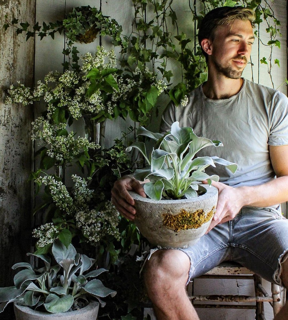 Carter Harrington with a potted plant in hand at Hort & Pott in Freehold NY