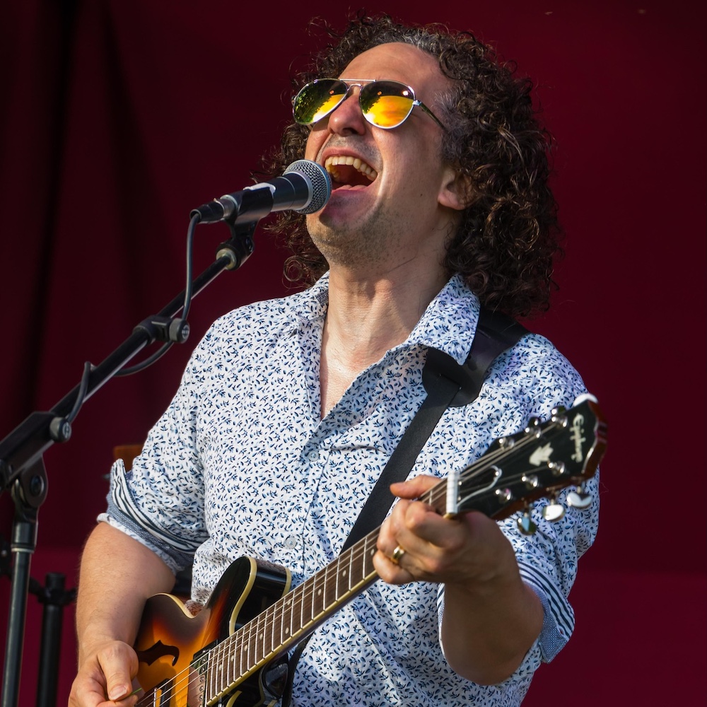 Doug Yoel playing guitar and singing