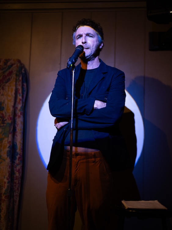Paul Willis on a stage doing stand-up comedy