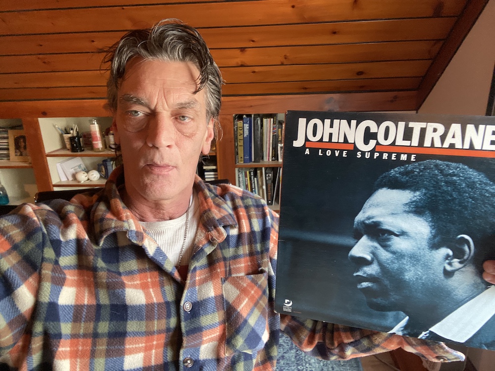Greg Cattine DJ Host at Radio Woodstock holding up a John Coltrane vinyl album 