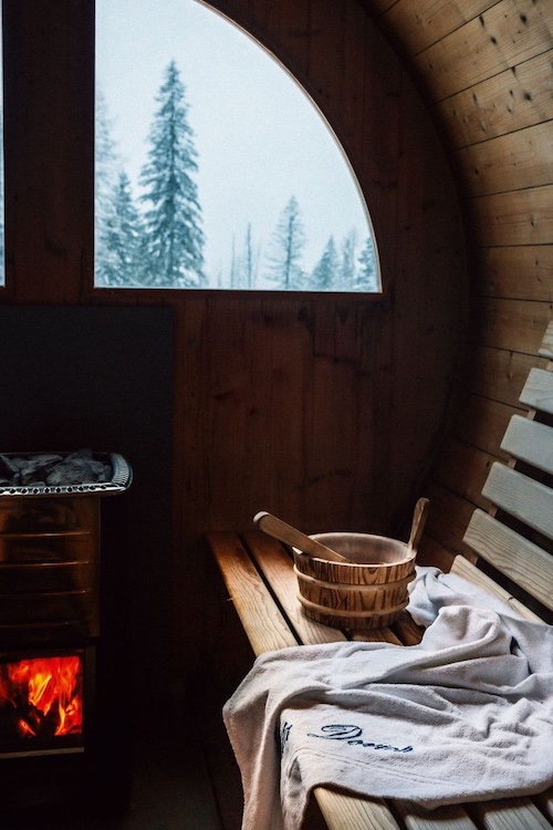 a bench, robe and bucket inside a sauna