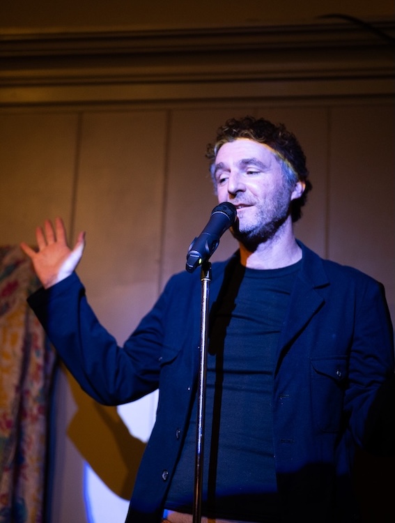 Paul Willis on a stage doing stand-up comedy