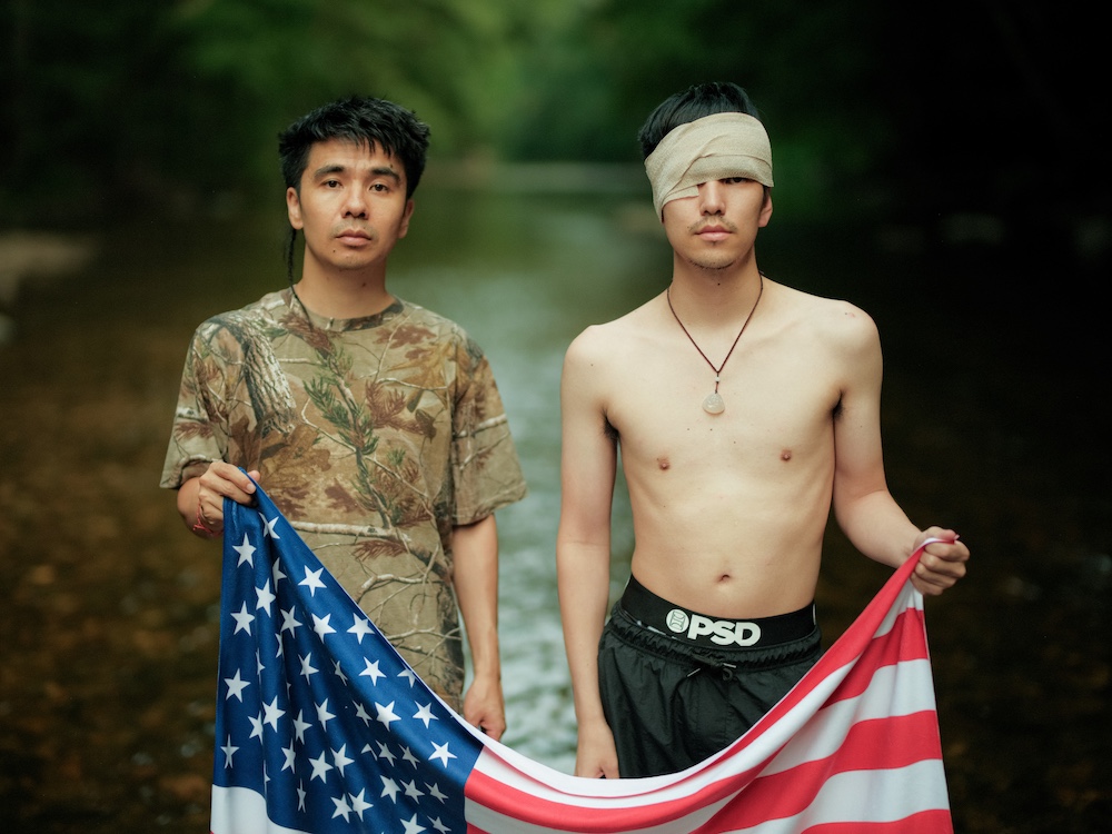 borthers holding an American flag by Ocean Vuong