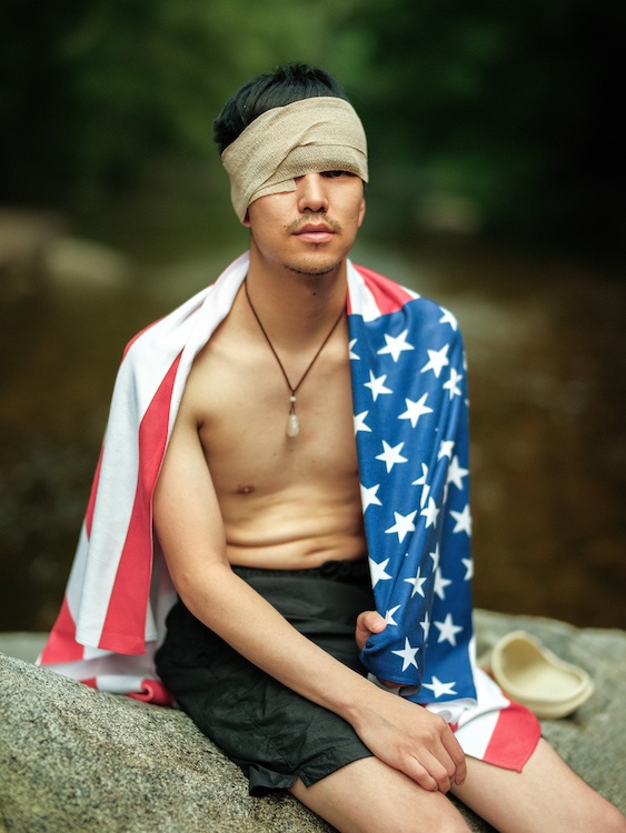 Nicky bandaged up and wrapped in the American flag by Ocean Vuong