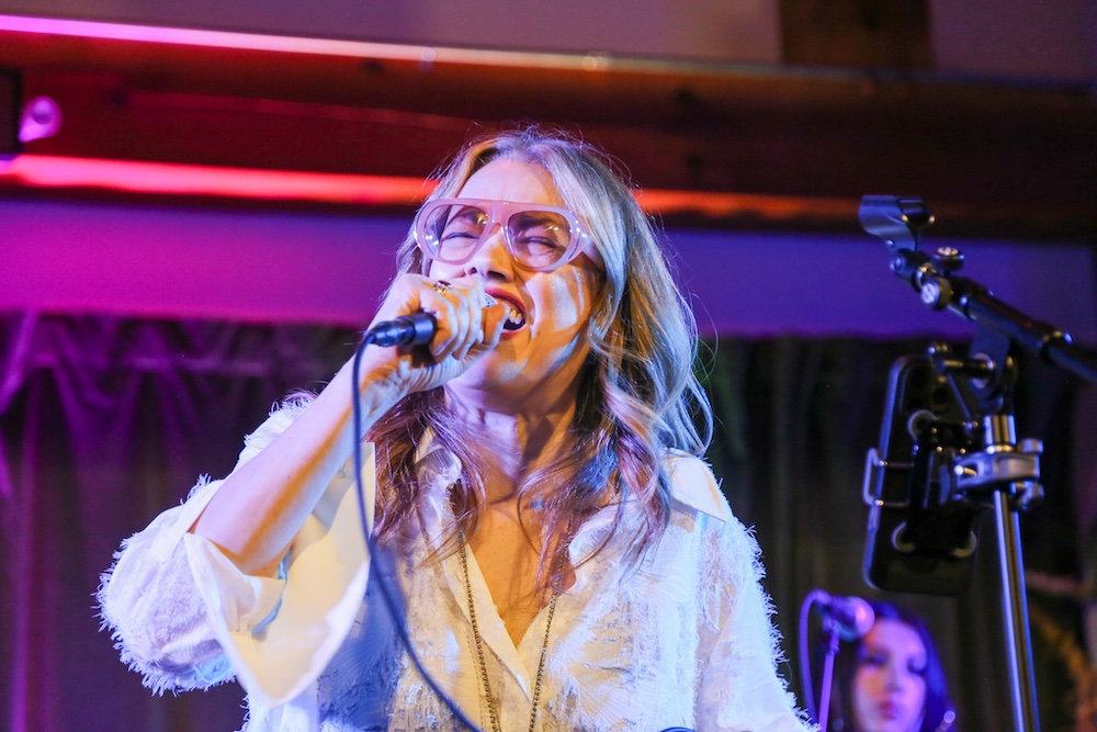 artisit singing on stage at In the Living Room at Full Circle in Gardiner NY