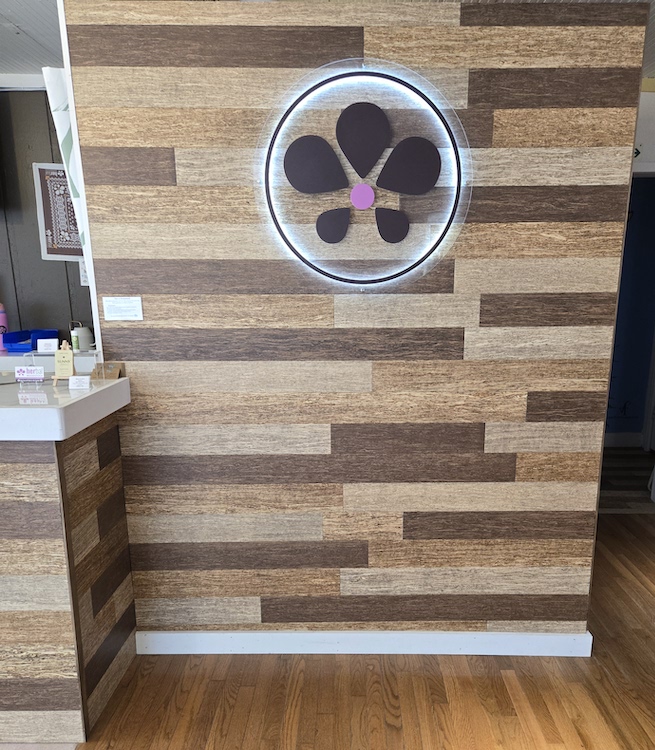 Wall of Wood and HERbal logo at HERbal Woodstock Cannabis Dispensary.