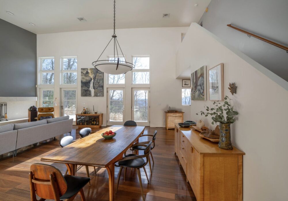 The gourmet kitchen boasts top-of-the-line Bosch and Wolf appliances, a built-in Sub-Zero refrigerator, a stone countertop, and a butler's pantry with a sink and a second refrigerator. The kitchen door leads out onto an expansive two-story screened porch designed for dining and lounging, and onto a 40-foot outdoor deck with black locust decking, where you can host dinner parties among the treetops.