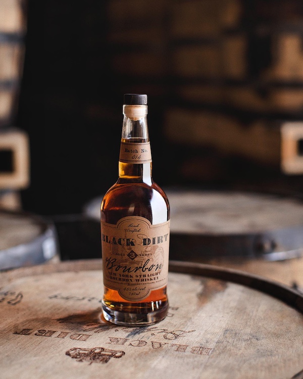 bottle of bourbon on a barrel by Black Dirt Distillery in Pine Island NY
