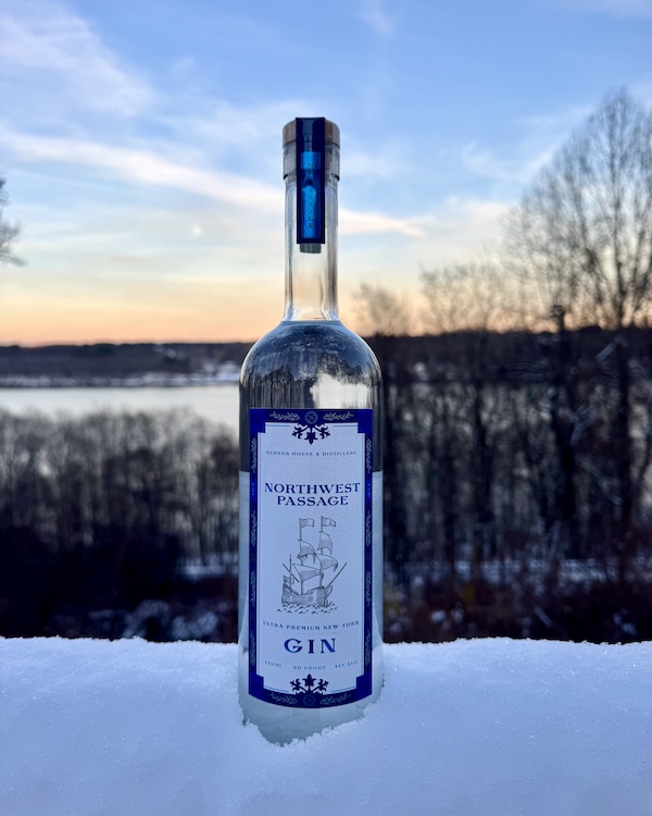 a bottle of Northwest Passage Gin in the snow at sunset by The Hudson House & Distillery in West Park NY