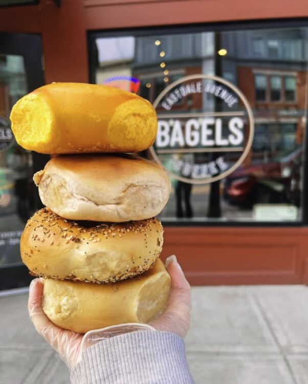 stack of bagels with front window of business behind at Eastdale Avenue Bagels in Poughkeepsie NY