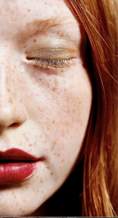 Face with freckles red hair and light spring makeup