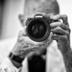Tony Levin holding his camera up to a mirror