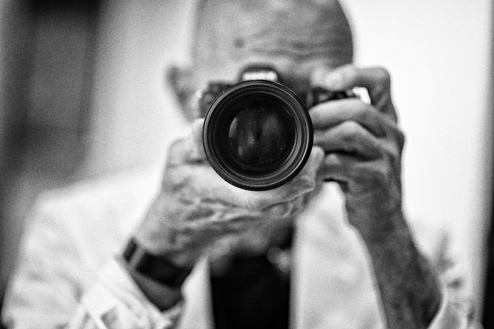 Tony Levin holding his camera up to a mirror