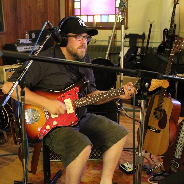 David Chapman in the studio playing guitar