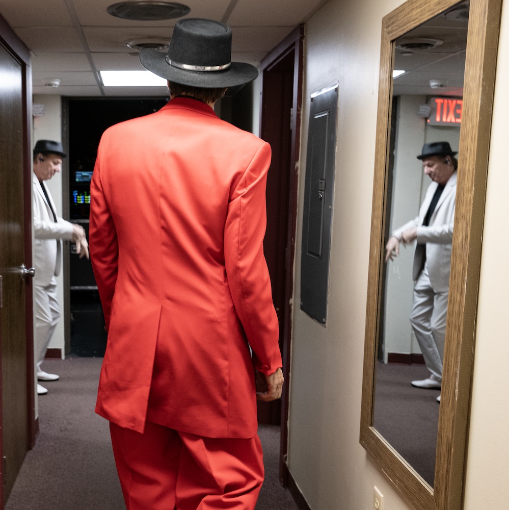 backstage musician with red suit on walking away from the camera