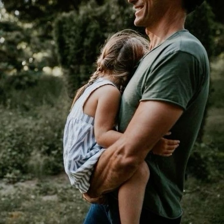 father holding daughter sundress smiling