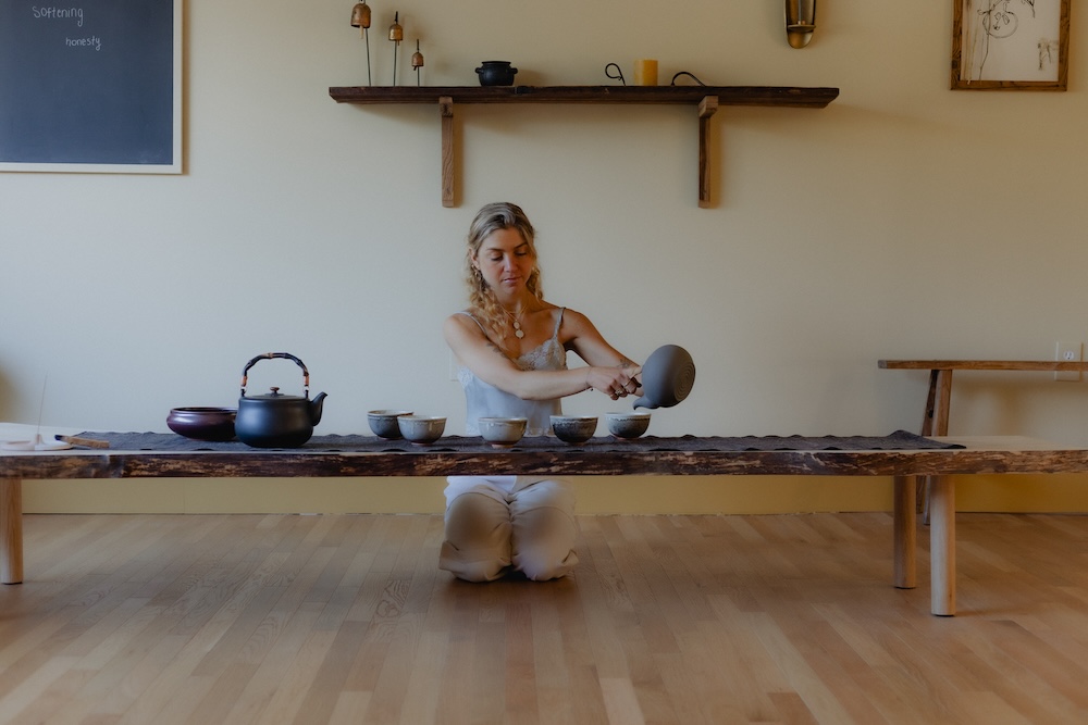 woman pouring tea out of tea pot for a tea ceremony