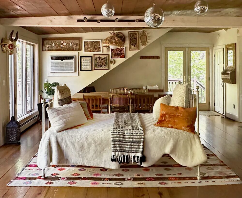 Disco balls in the living room that has a bed-couch in the middle of the room.
