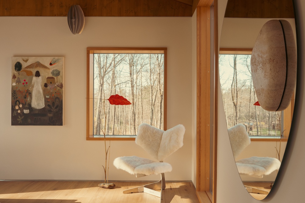 The guest bedroom with a window, artful chair and red lamp at Ohayo Mountain House in Glenford NY.