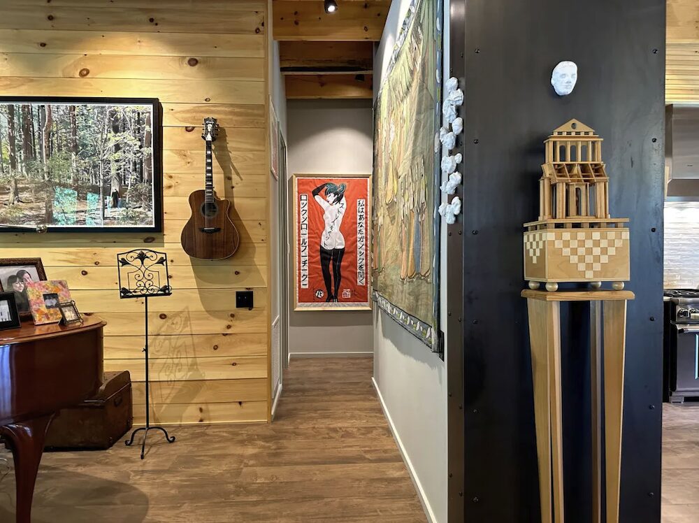 Hallway, piano, paintings and sculptures placed all around.