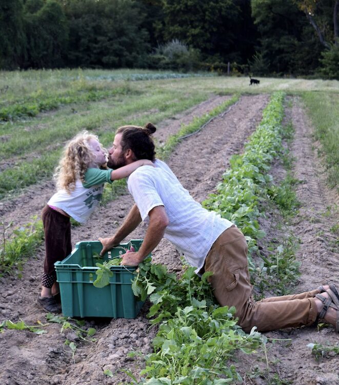 father and child farming kisses growing vegtables