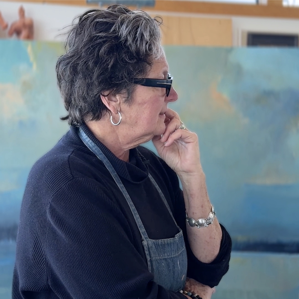 Artist Kate McGloughlin pondering a painting in her studio.