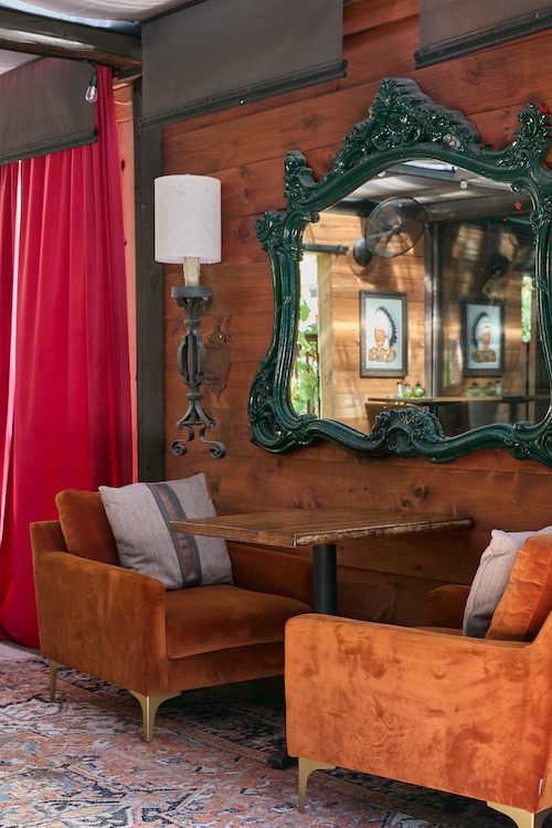 Interior shot of two couch chairs with table and mirror at Peekamoose Restaurant & Taproom in Big Indian NY.