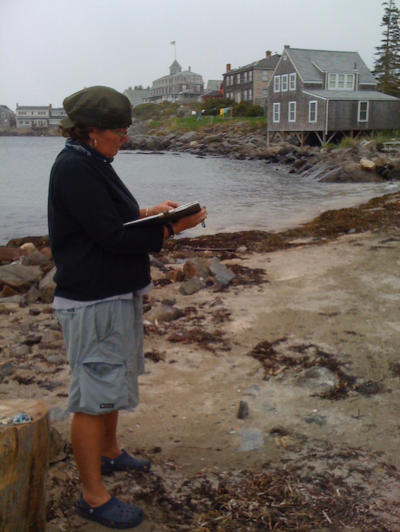 Pleinair painting. Artist Kate McGloughlin working on the beach. Monhegan Island, ME.