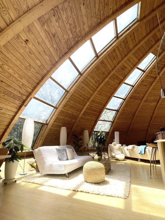 Couch in the living room with a dome ceiling with vertical windows between panels.