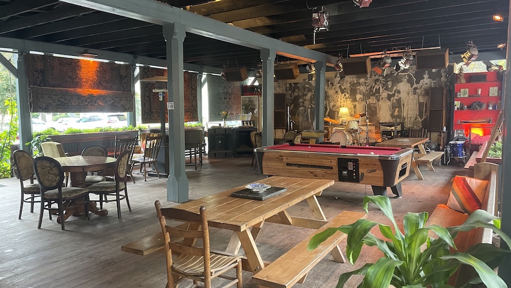 Station Bar & Curio Pavilion with pool table, seating and a stage.