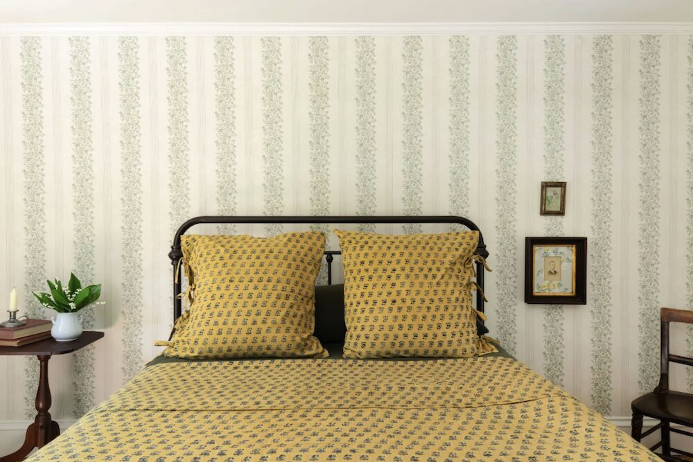 Bed pillows and wallpaper with side furniture at 809 North Quaker Hill Road, Pawling NY.